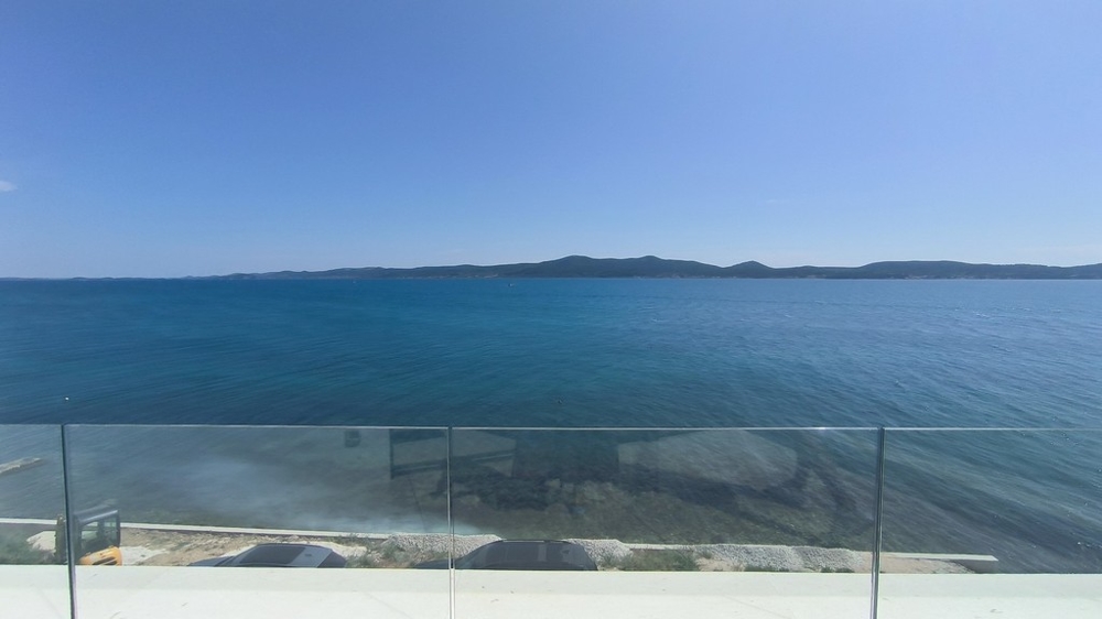 Garde-corps en verre de la terrasse devant l'eau d'un bleu profond