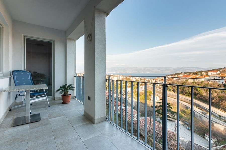 Loggia avec chaise longue et vue sur la baie jusqu'aux montagnes