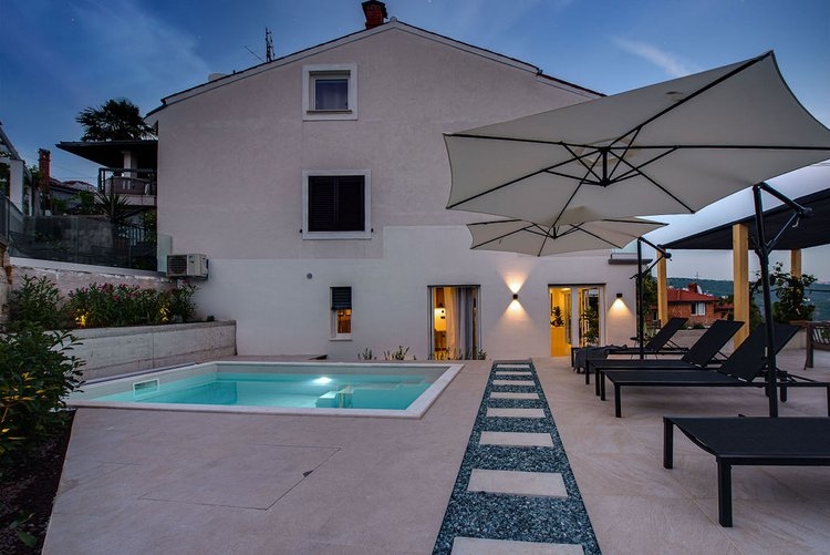 Piscine et terrasse avec transats au crépuscule