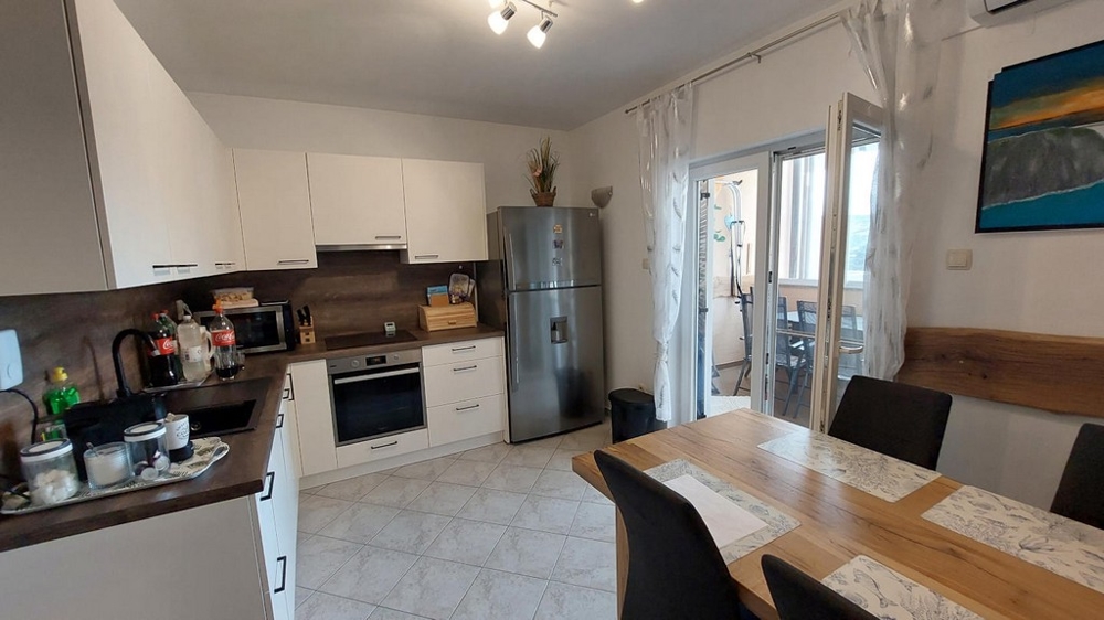 Grande cuisine avec coin repas et accès au balcon
