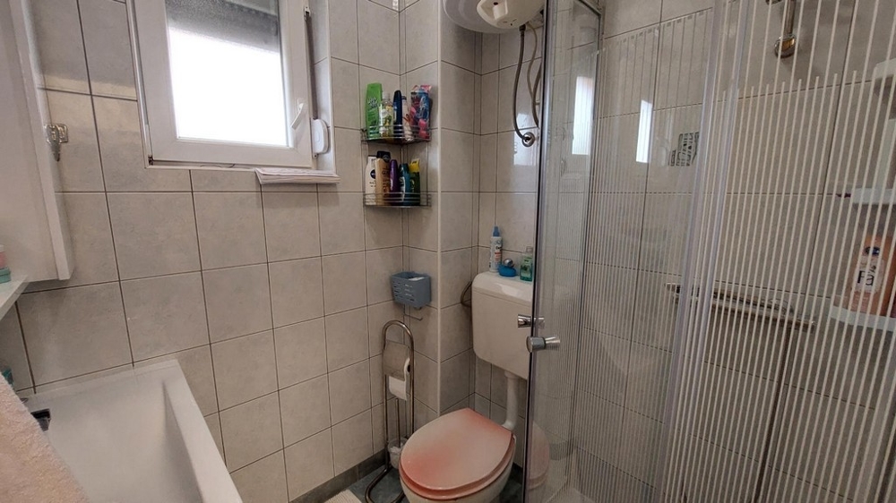 Salle de bains avec douche et fenêtre