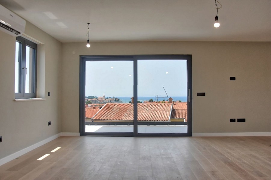 Séjour ouvert avec parquet et vue sur les toits istriens, partie d'un penthouse à vendre.