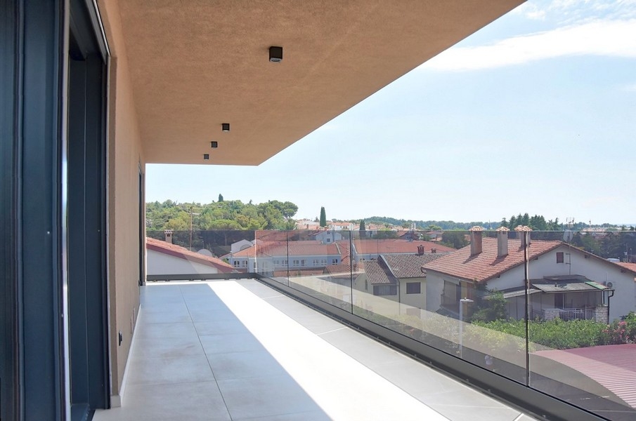 Balcon couvert d'un penthouse en Istrie avec vue sur l'architecture locale et la mer.