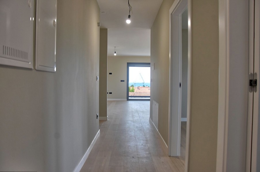 Couloir dans un penthouse proposé à la vente en Istrie, menant à une pièce avec vue mer.