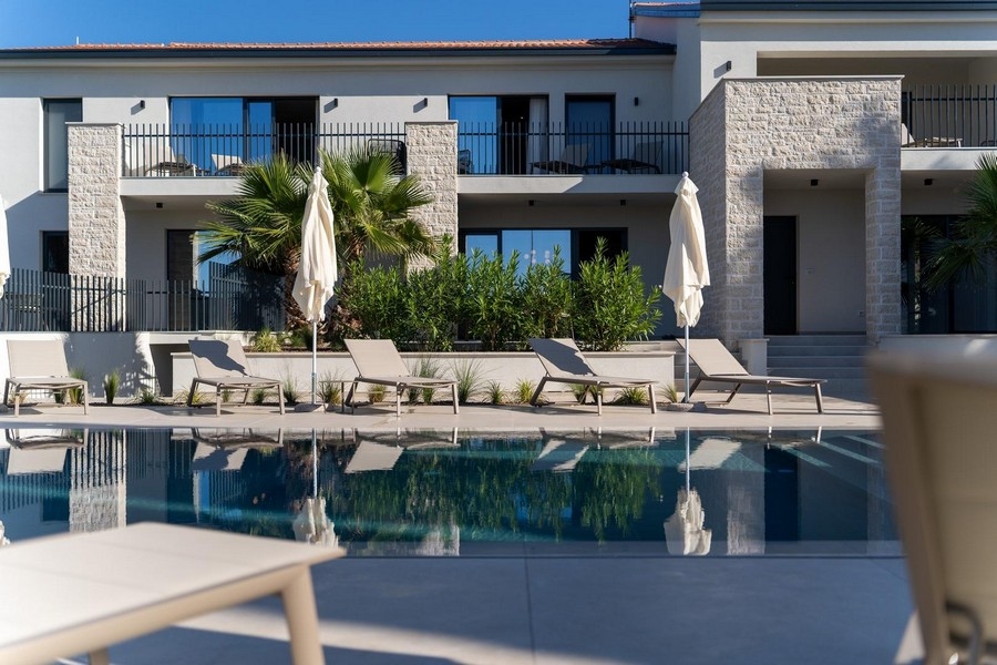 Appartement de luxe en Istrie avec bâtiment moderne et piscine, chaises longues et jardin entretenu