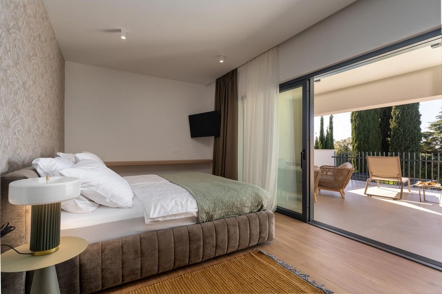 Chambre avec grandes surfaces vitrées et accès à la terrasse dans un appartement de luxe en Istrie
