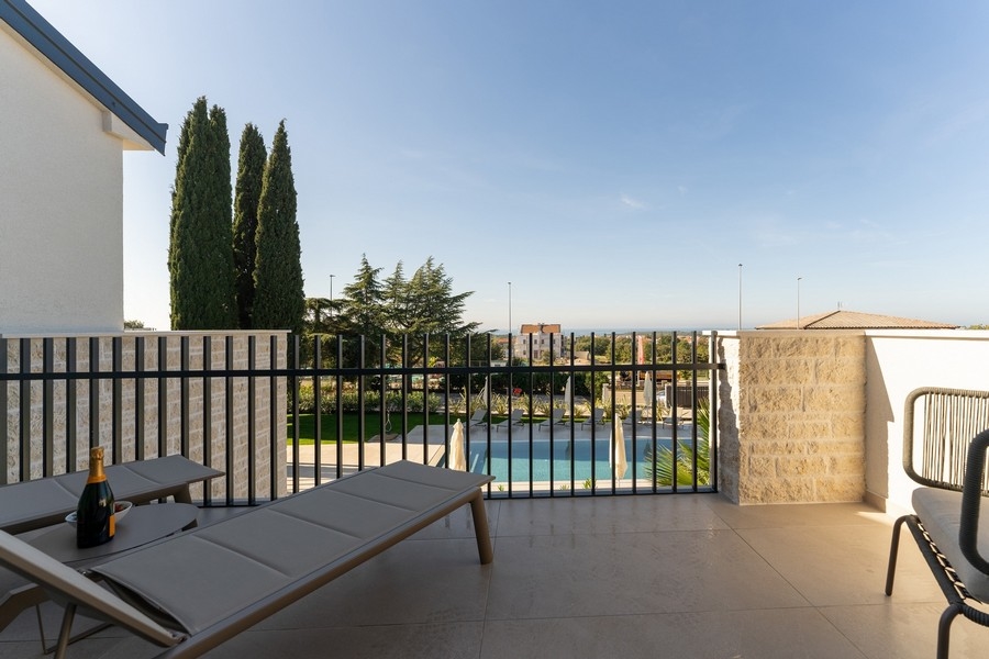 Vue depuis la terrasse sur la piscine et la mer près d'un bien de luxe en Istrie