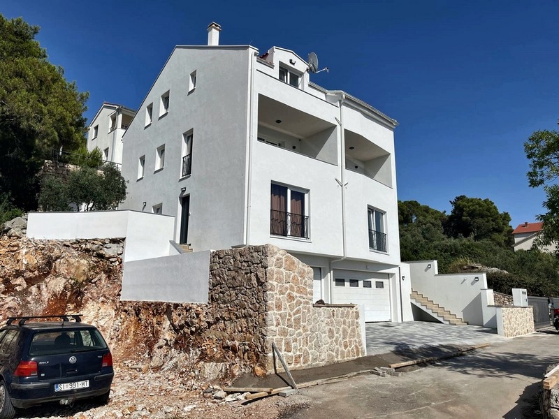 Vue extérieure du bien, façade moderne avec garage et escalier d'accès