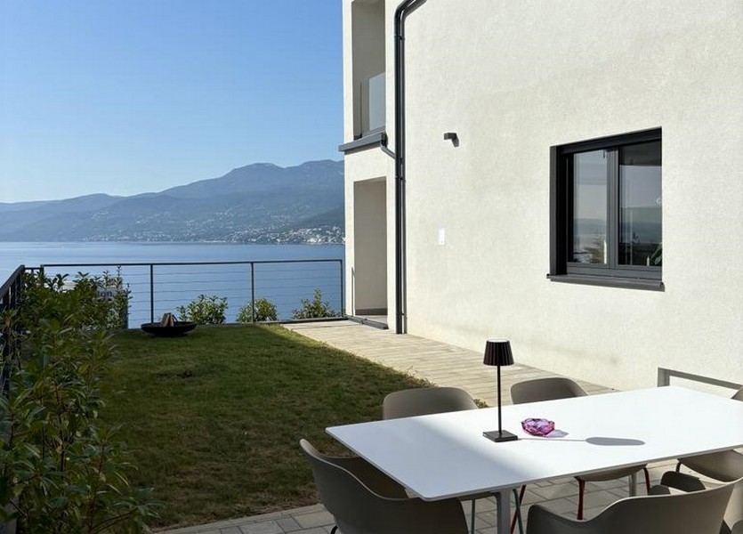 Terrasse avec table et chaises blanches et vue sur la mer, appartement à vendre à Rijeka, Croatie.
