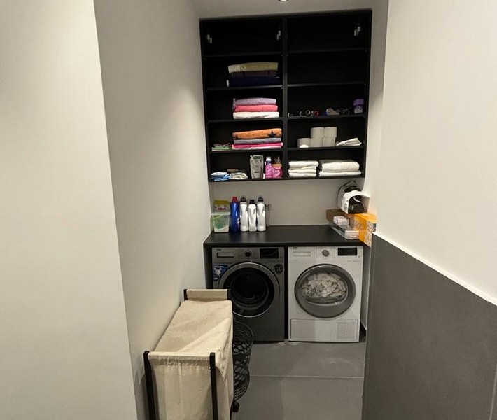 Coin buanderie avec lave-linge et placard intégré pour les serviettes, partie d'un appartement à vendre à Rijeka, Croatie.