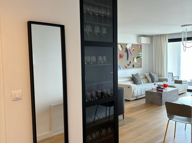 Élégant porte-bouteilles à côté d'une porte vitrée noire, détail d'un appartement à vendre à Rijeka, Croatie.
