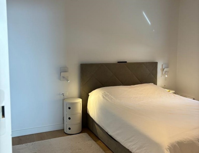 Chambre minimaliste avec grand lit et table de chevet, partie des biens à Rijeka, Croatie.