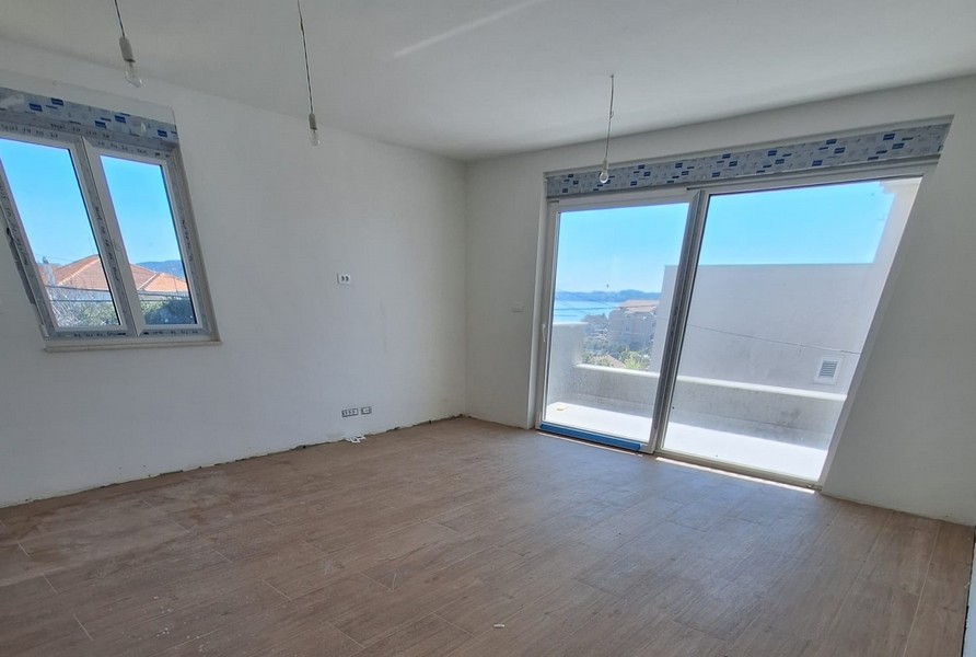 Pièce vide avec parquet et façade vitrée avec vue mer