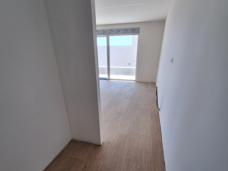 Pièce vide dans un programme neuf avec parquet et porte de balcon