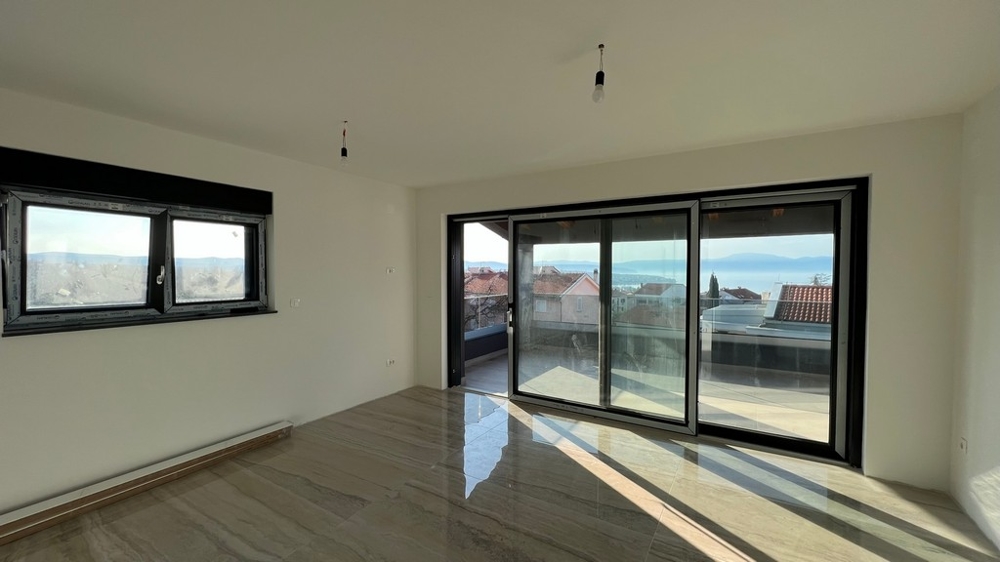 Vaste salon avec grandes surfaces vitrées et accès à la terrasse, un rêve pour les biens immobiliers en Croatie.