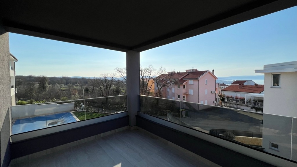 Loggia avec garde-corps en verre et vue sur les maisons voisines