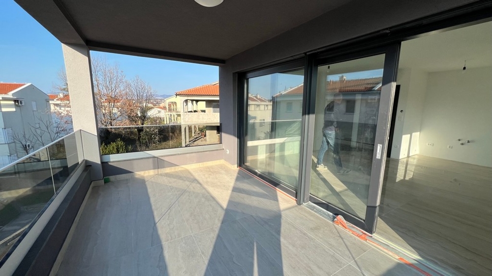 Spacieuse terrasse avec grandes fenêtres vitrées, un atout du bien moderne sur l'île de Krk.