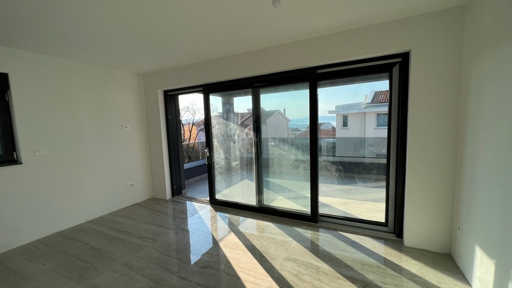 Séjour lumineux avec baies vitrées jusqu'au sol, s'intègre au concept moderne du bien sur l'île de Krk.