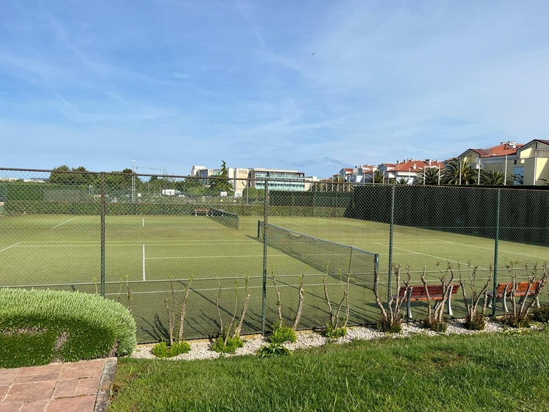 Court de tennis avec clôture et bancs dans la résidence