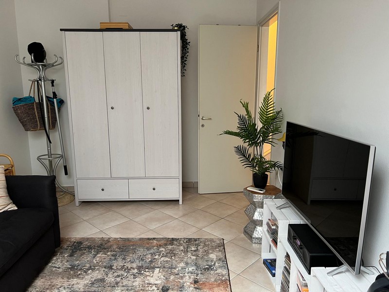 Armoire blanche, télévision et porte dans la pièce de vie