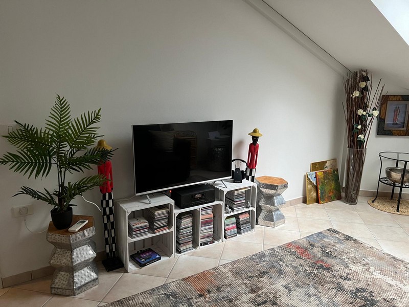 Télévision sur des caisses de rangement blanches avec CD et figurines décoratives
