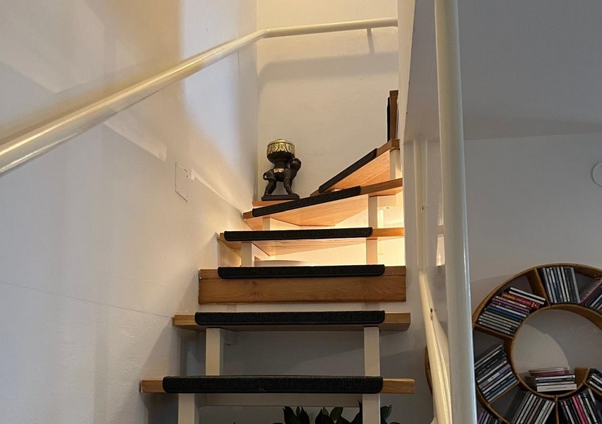 Escalier ouvert en bois avec main courante vers l'étage