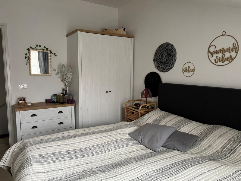 Chambre avec lit double, commode et armoire blanche