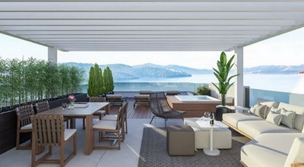 Terrasse couverte avec espace lounge et vue mer