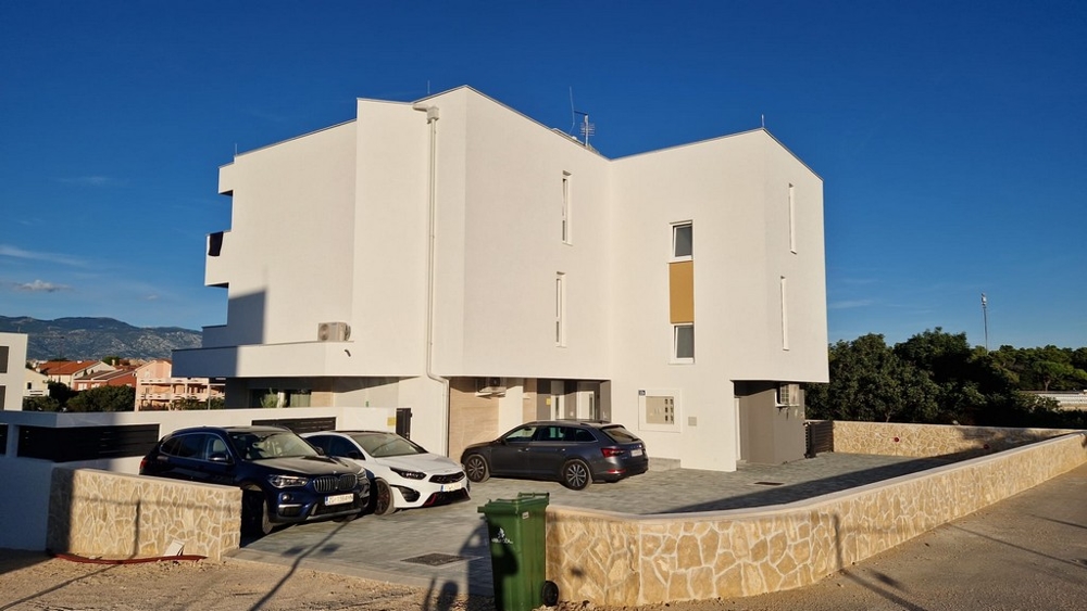 Vue latérale d'un immeuble d'appartements moderne avec places de parking à Novalja, île de Pag, biens immobiliers Croatie