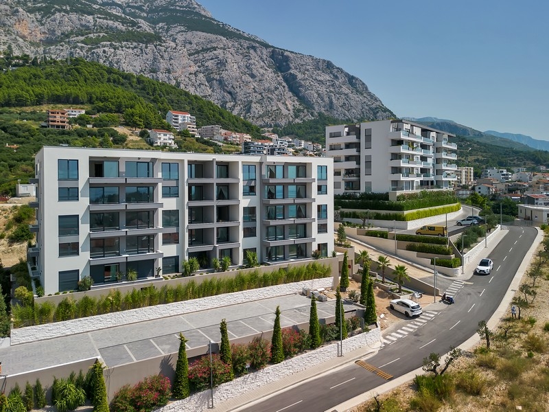 Biens immobiliers en Croatie, Makarska, appartement avec vue mer : vue aérienne d'un ensemble résidentiel moderne avec montagne à l'arrière-plan
