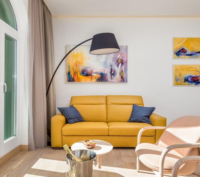 Salon lumineux avec canapé jaune, idéal pour les personnes intéressées par des biens immobiliers en Croatie