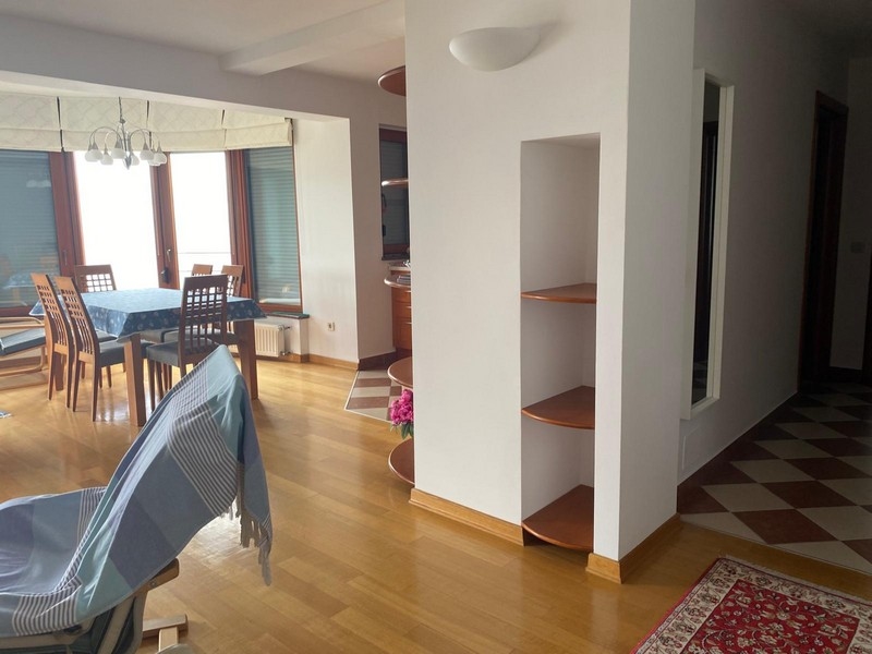 Séjour avec coin repas et couloir au carrelage en damier