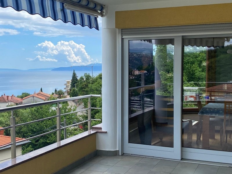 Balcon avec porte coulissante en verre et vaste vue mer