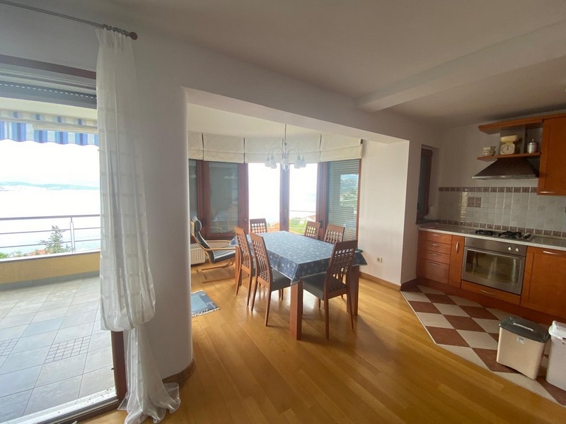 Cuisine lumineuse et coin repas avec vue mer dans le bien en Croatie.