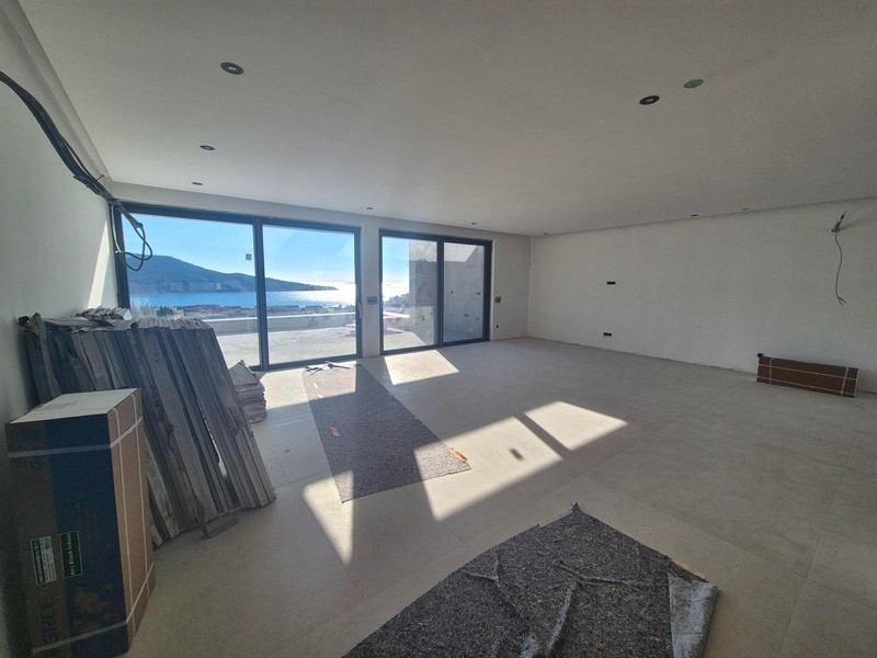 Pièce de vie avec grande façade vitrée et vue mer