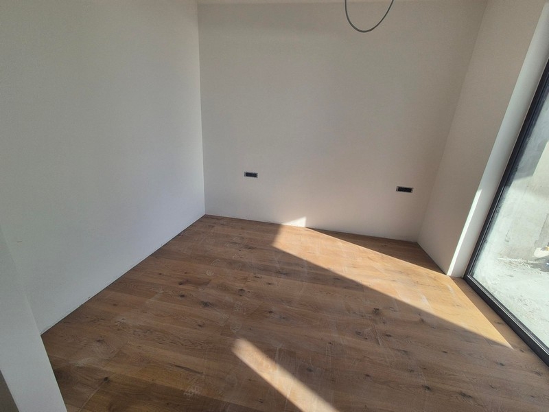 Chambre avec parquet et fenêtre à hauteur d'étage