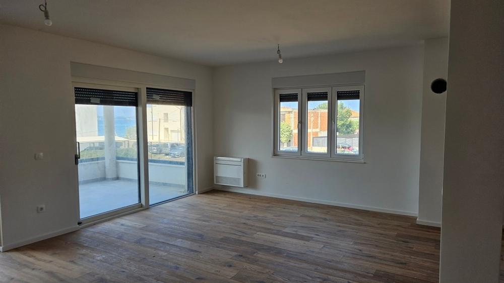Séjour avec parquet et radiateur au mur.