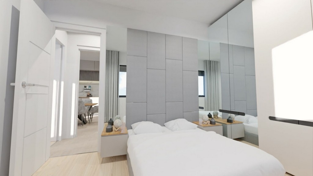 Chambre lumineuse avec miroirs, meubles blancs et accès aux pièces de vie.