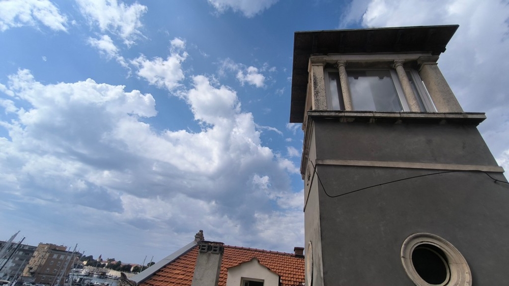 Tour au-dessus des toits de tuiles sous un ciel nuageux