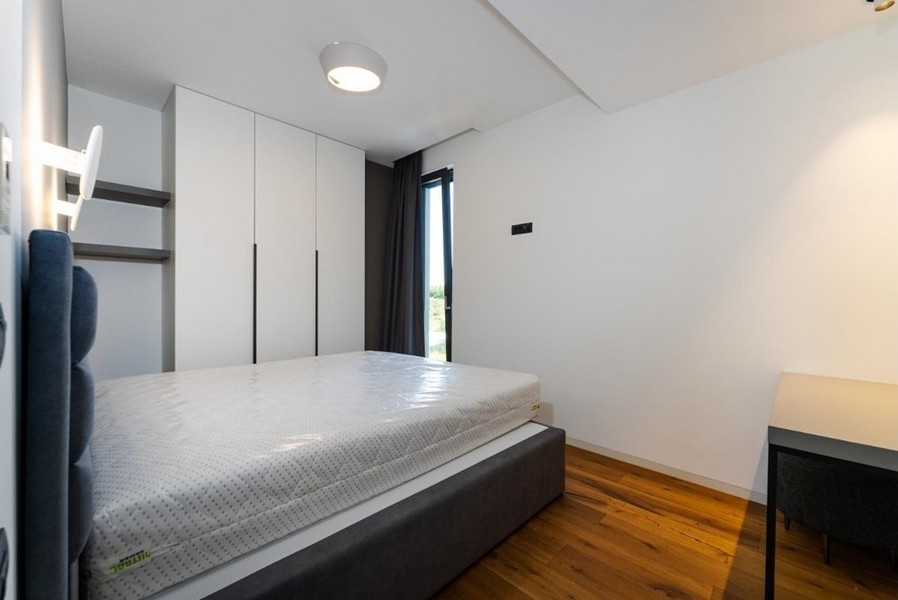 Chambre avec placards blancs, lit gris, bureau