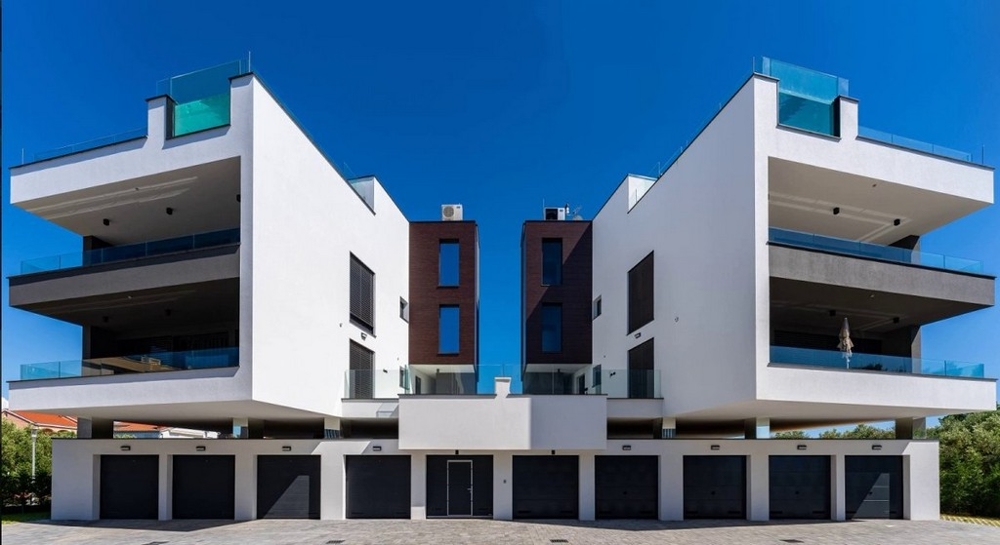 Deux bâtiments symétriques avec rangée de garages en soubassement