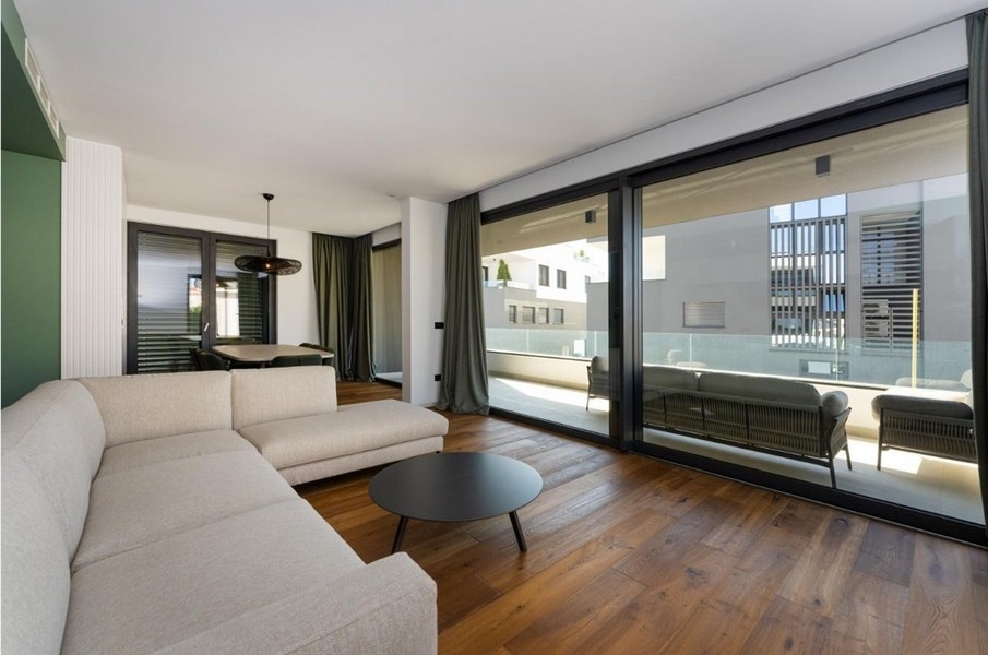 Coin repas avec table ronde et chaises, accès au balcon
