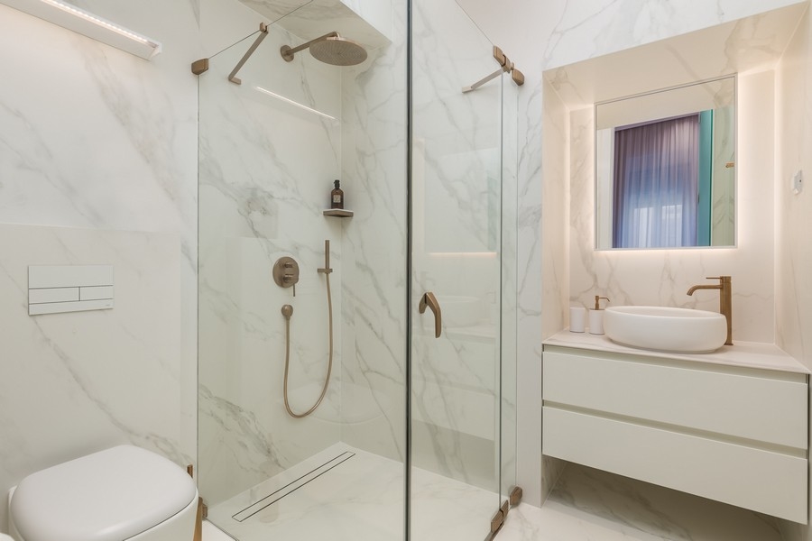 Salle de bains moderne avec douche en verre et carreaux de marbre