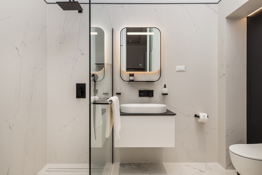 Deuxième salle de bains moderne avec douche en verre et miroir