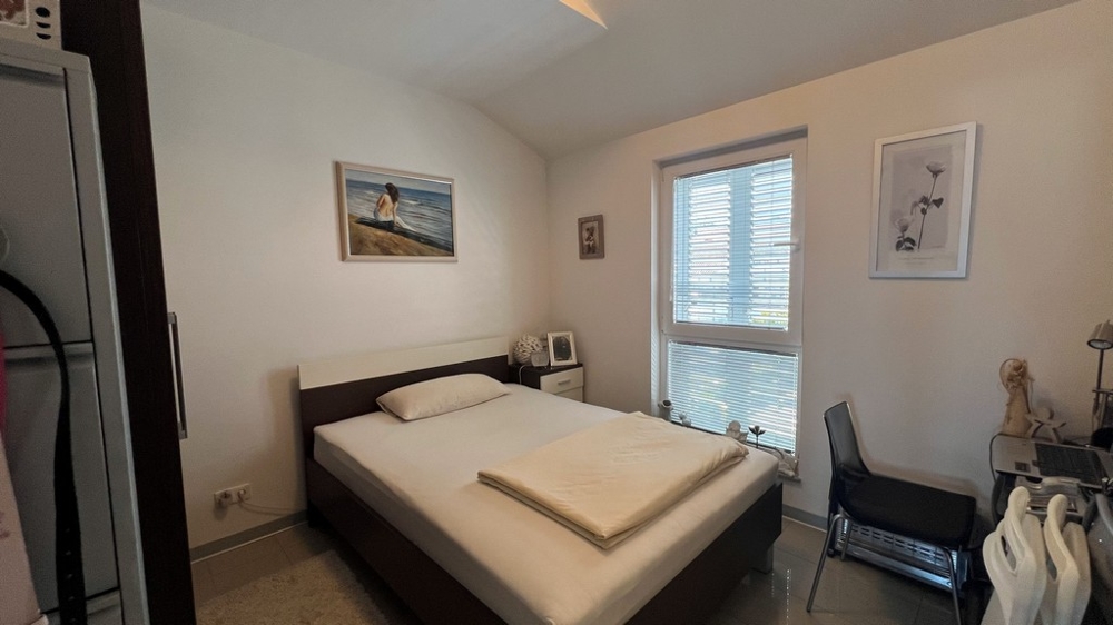 Chambre avec lit double, aménagement sobre et fenêtre donnant sur le jardin.
