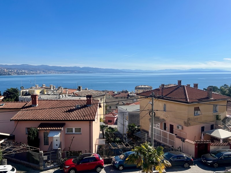 Vue sur les toits de tuiles et les voitures jusqu'à la vaste baie
