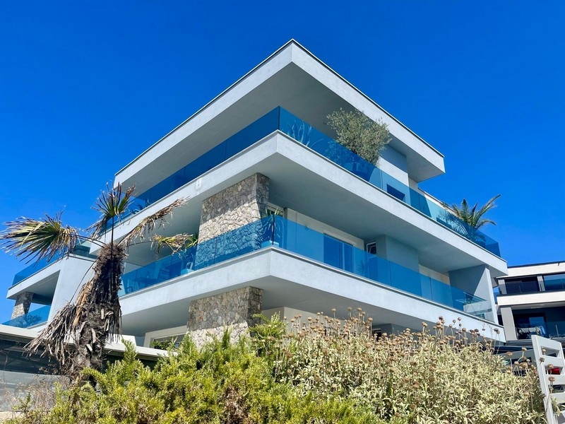 Bâtiment avec garde-corps en verre bleu et colonne en pierre naturelle
