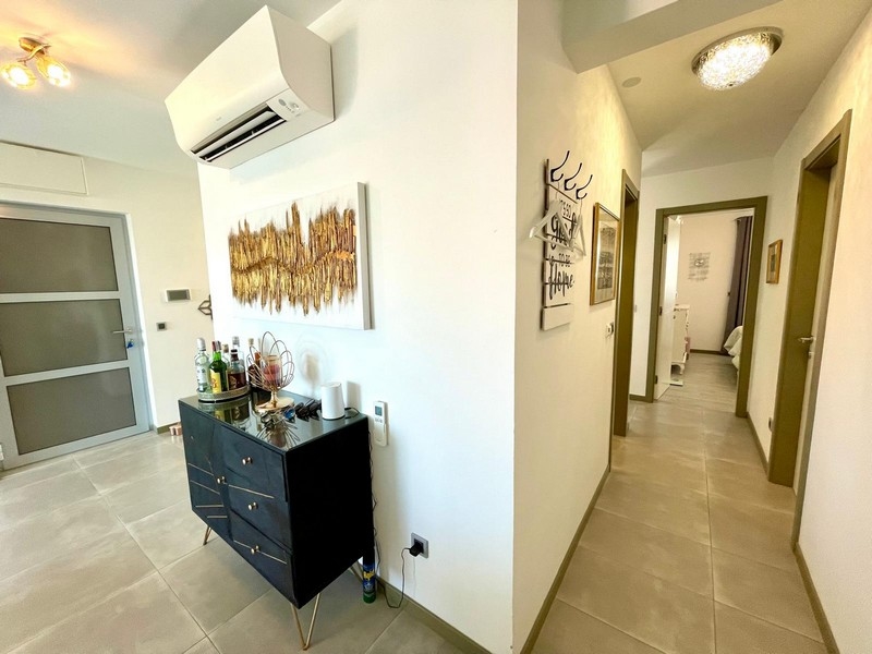 Couloir et entrée avec carrelage foncé et moderne.