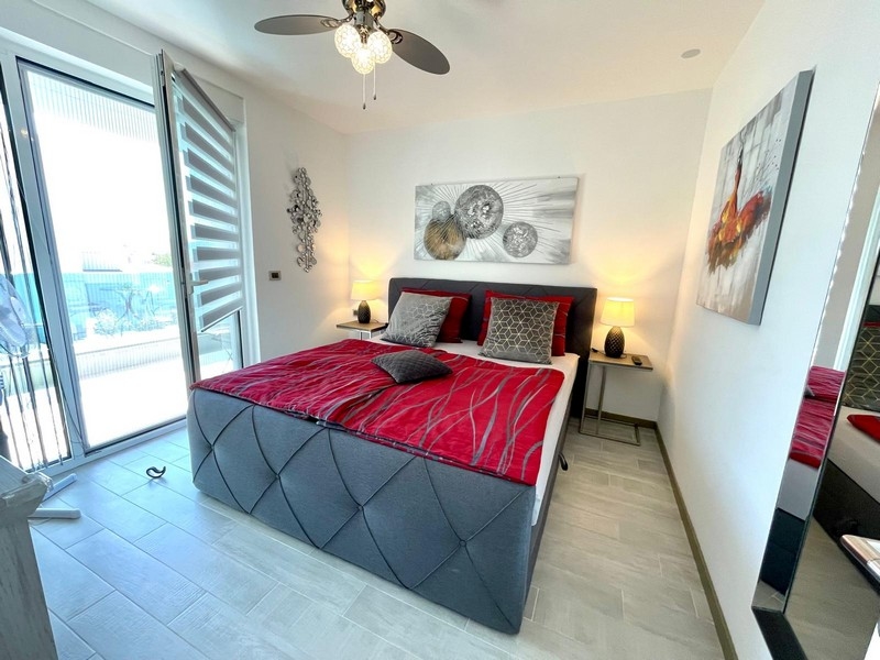 La chambre avec accès à la terrasse du bien.