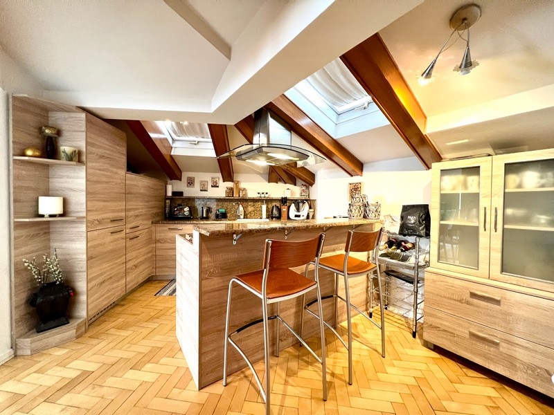 Cuisine moderne avec placards en bois, îlot de cuisine et tabourets de bar